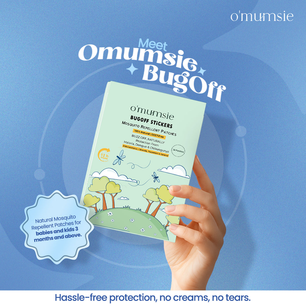 Hand holding o'mumsie BugOff mosquito repellent patches against a blue background with brand name displayed.